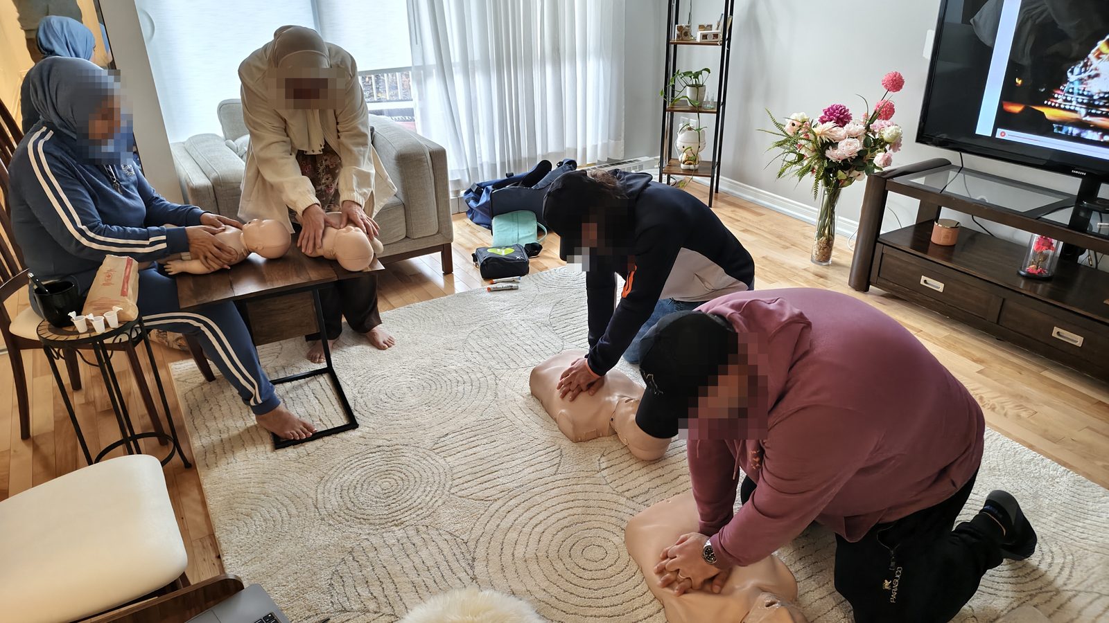 Formation de secourisme à domicile : des participants pratiquent la RCR adulte et bébé dans un salon