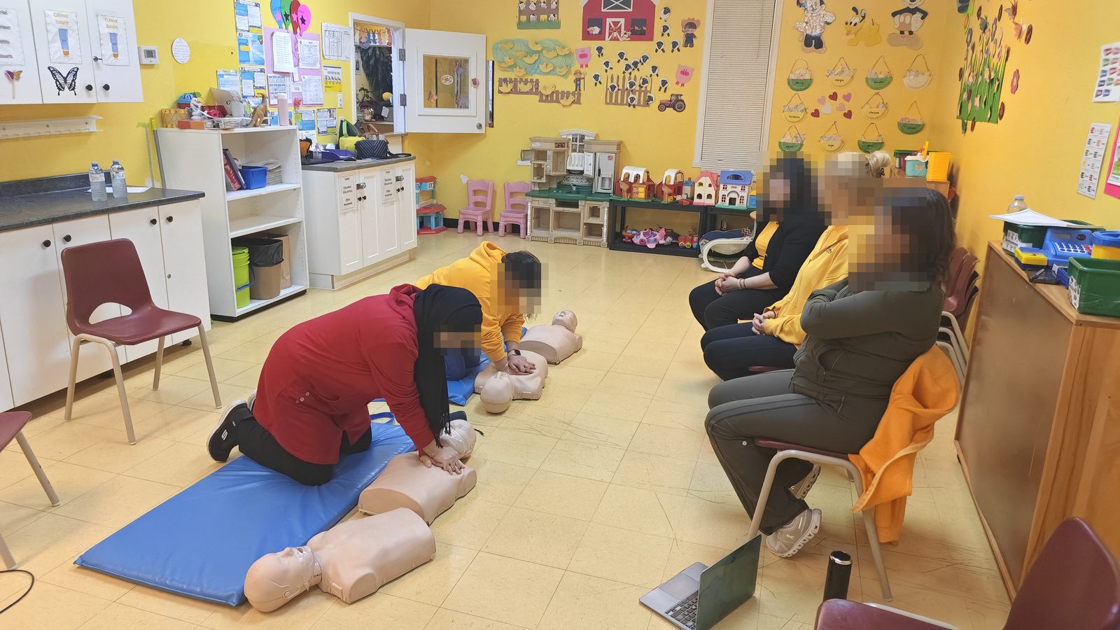 Formation de secourisme dans une garderie : des éducatrices pratiquent la RCR sur des mannequins