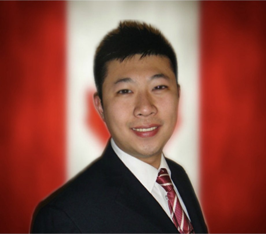 Portrait de Shengbo Yu en complet, devant le drapeau du Canada
